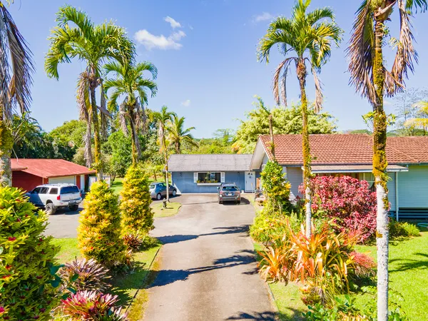 a front view of a house with a yard and garden