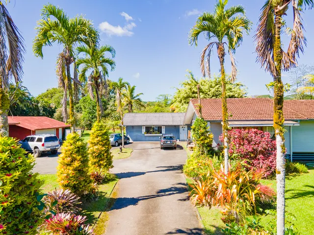 a front view of a house with a yard and garden