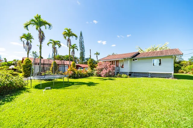 a front view of house with yard and swimming pool