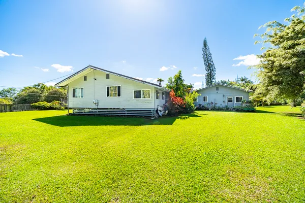 a front view of a house with yard and swimming pool