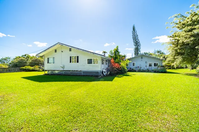 a front view of a house with yard and swimming pool