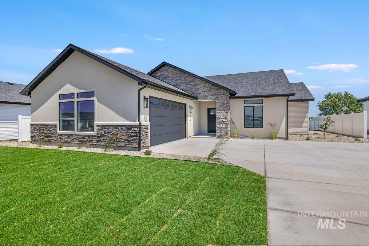 951 Gregory Way Twin Falls, ID 83301 - Photo 1 of 31 View of front of house featuring driveway, stone siding, a garage, and stucco siding