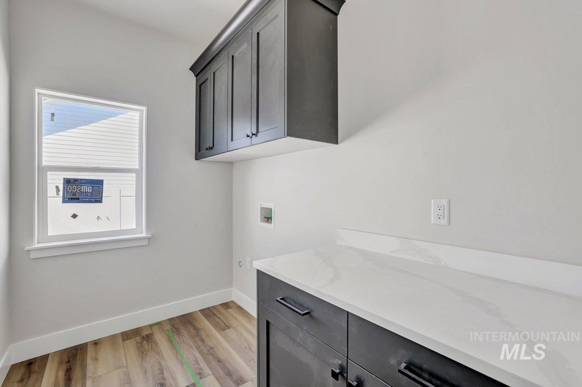 951 Gregory Way Twin Falls, ID 83301 - Photo 19 of 31 Laundry room featuring cabinet space, washer hookup, plenty of natural light, and light wood-type flooring