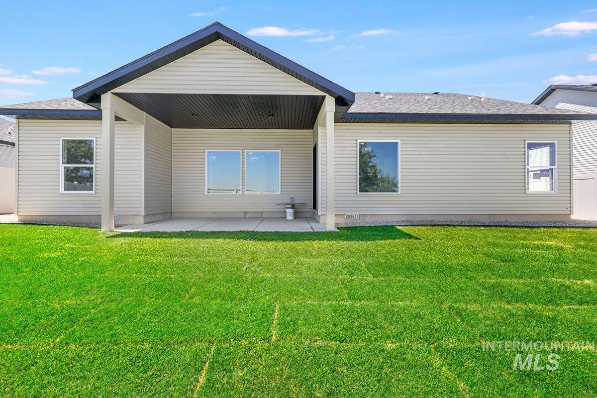 951 Gregory Way Twin Falls, ID 83301 - Photo 27 of 31 Back of property featuring a patio area, a lawn, and a shingled roof