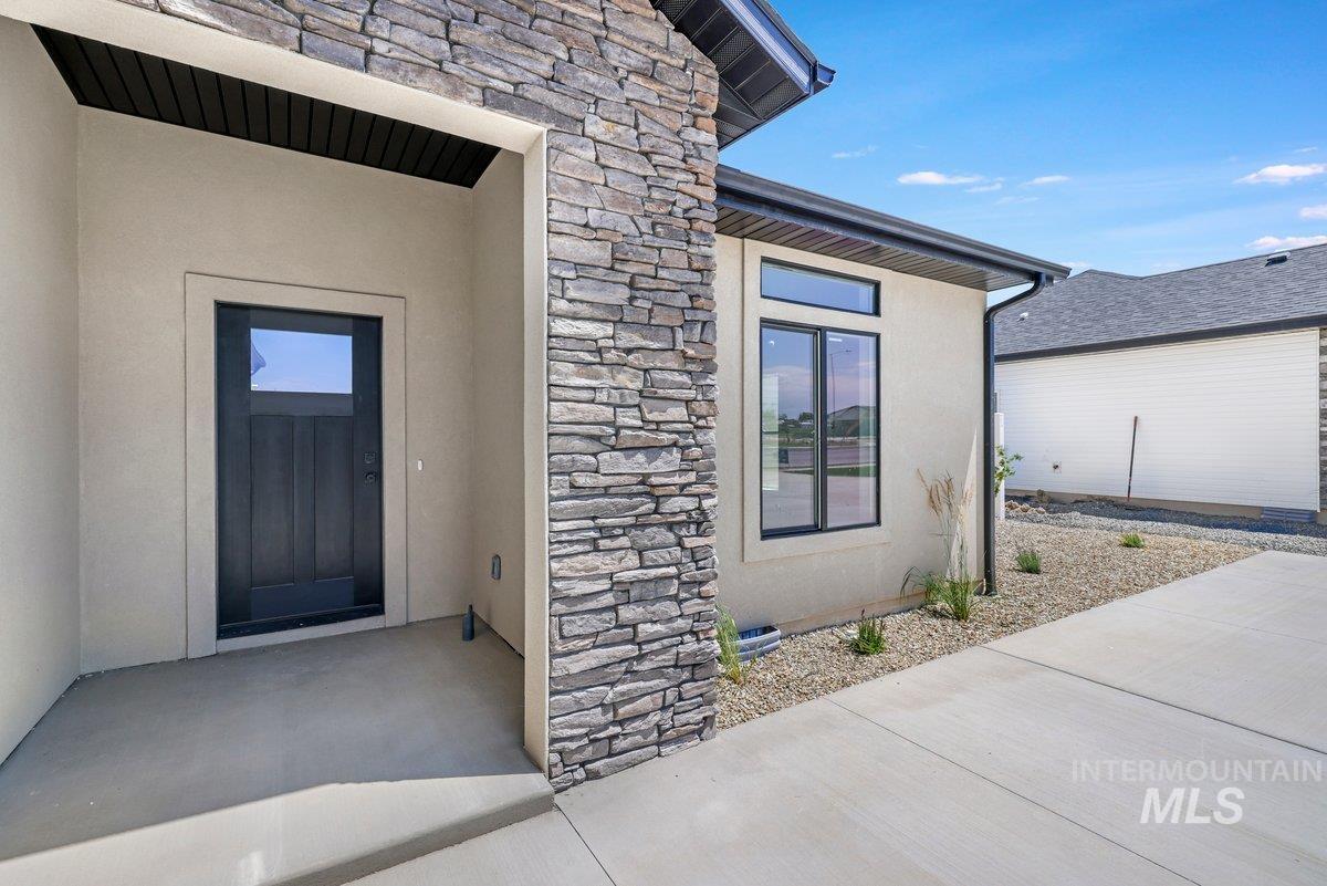 951 Gregory Way Twin Falls, ID 83301 - Photo 3 of 31 Property entrance featuring stone siding, a patio area, and stucco siding