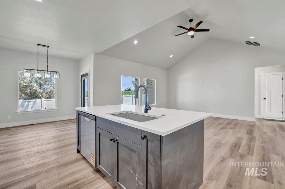 951 Gregory Way Twin Falls, ID 83301 - Photo 31 of 31 Kitchen featuring light countertops, open floor plan, lofted ceiling, light wood-style flooring, and gray cabinets