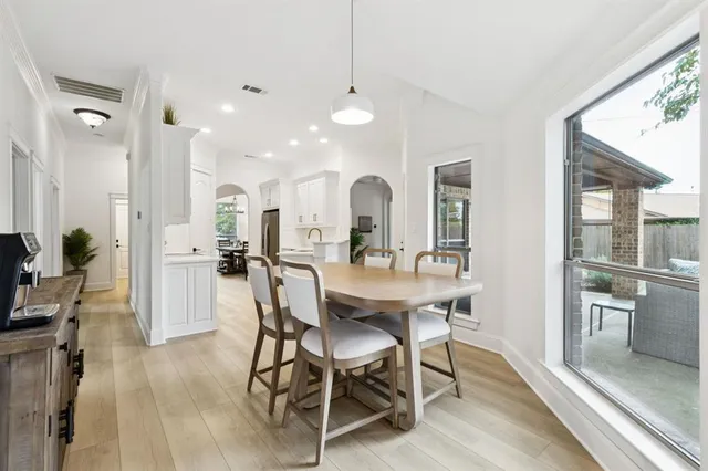 a view of a a dining room with furniture window and wooden floor
