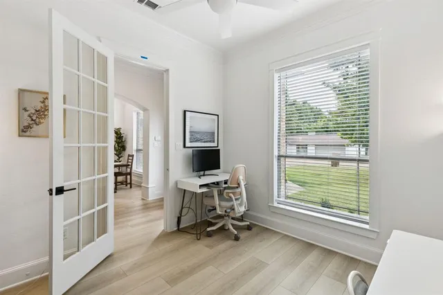 a view of a workspace with furniture and a window
