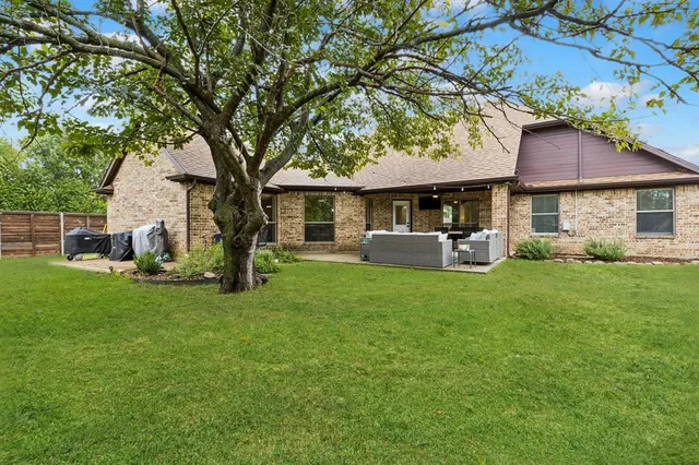 a front view of a house with a garden and trees