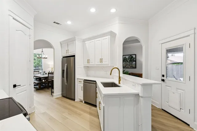 a kitchen with a sink a refrigerator and cabinets
