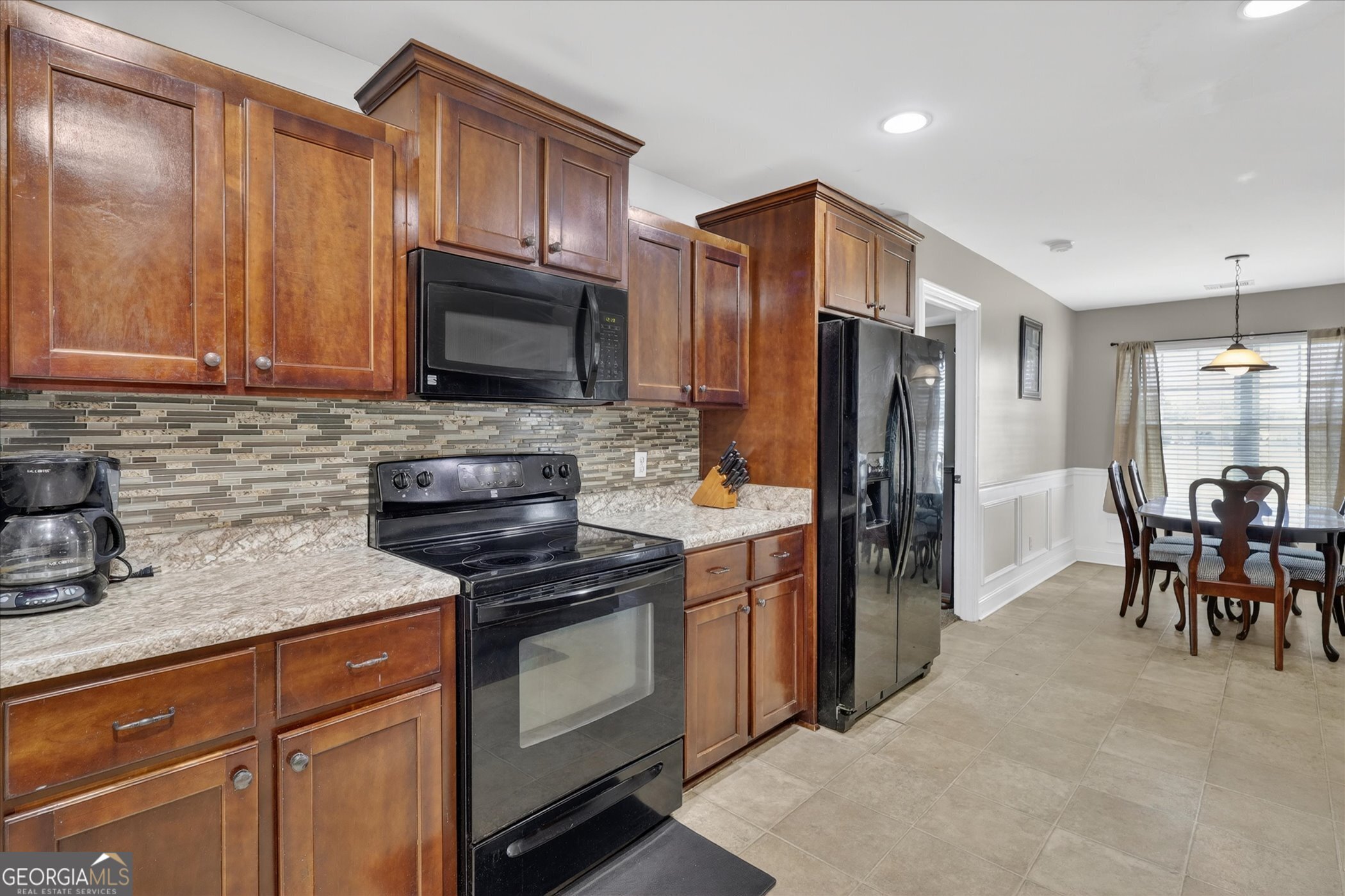 245 Stonebrook Way Statesboro, GA 30458 - Photo 12 of 32 a kitchen with granite countertop wooden cabinets a stove a refrigerator and a sink