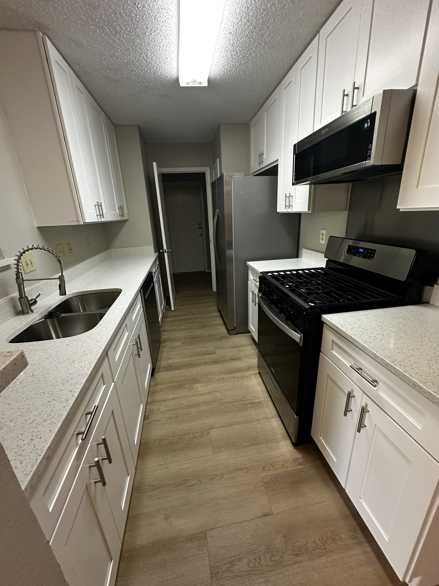 7900 West Gate Boulevard, Unit B Austin, TX 78745 - Photo 4 of 16 Modern kitchen with sleek white cabinetry and stainless steel appliances.