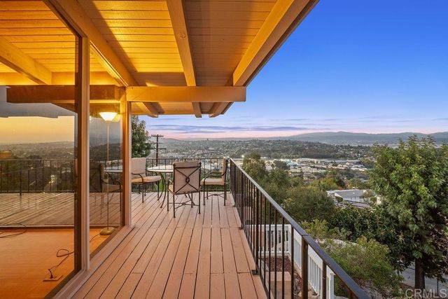 a view of a balcony with chairs and wooden floor