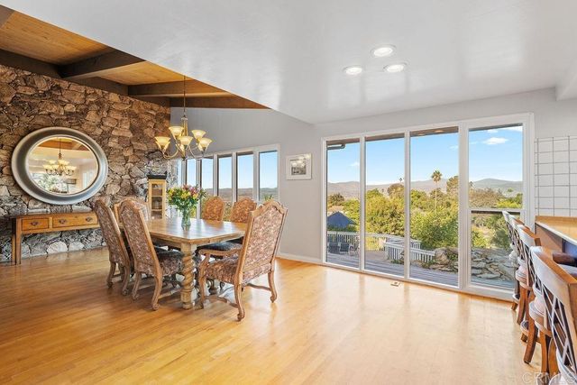 a dining room with furniture a floor to ceiling window and potted plants