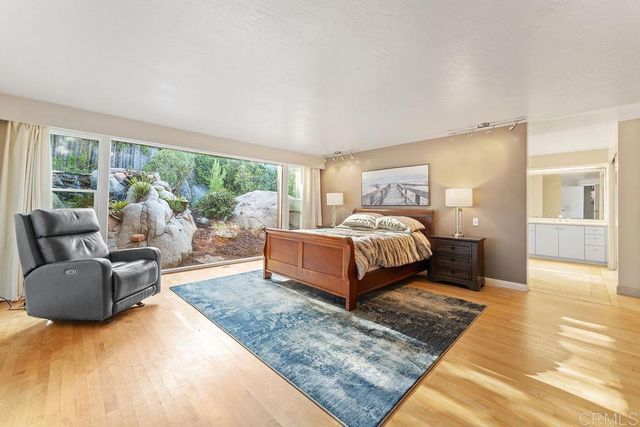 a bedroom with a bed couch and large window