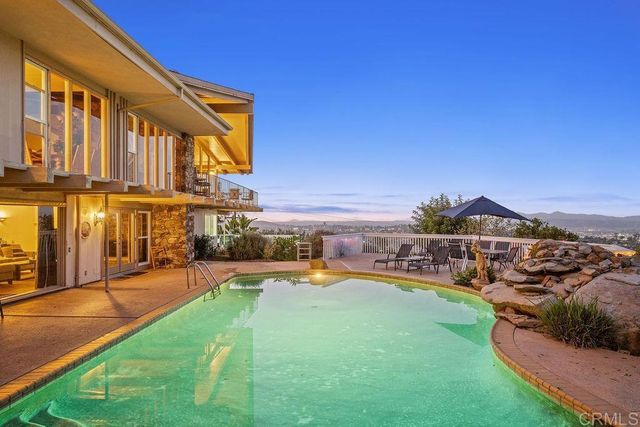 a view of a house with swimming pool and sitting area