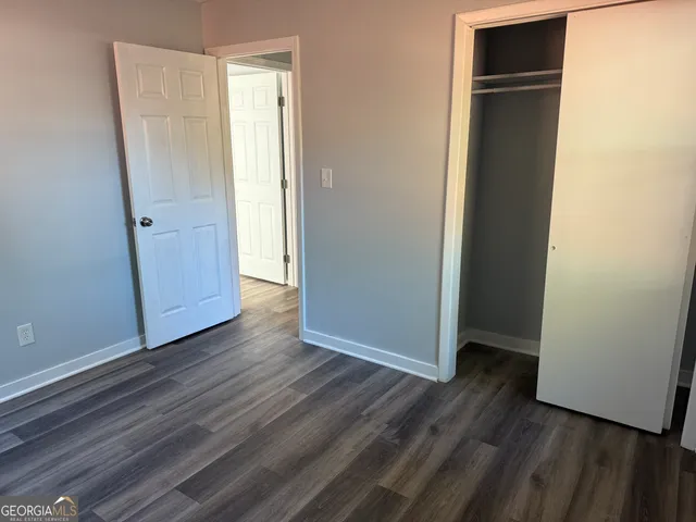 an empty room with wooden floor and closet