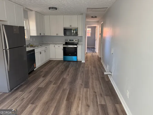 a kitchen with wooden floors and refrigerator