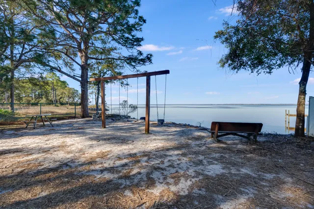 a view of a house with backyard and trees