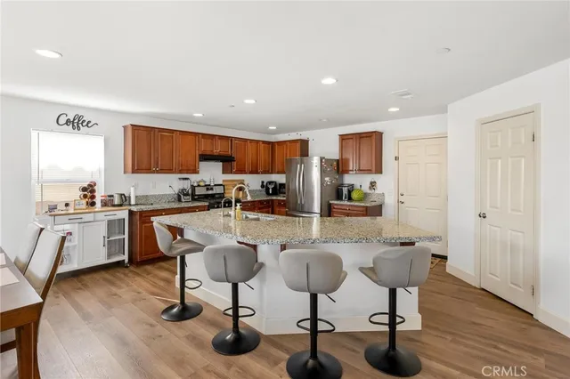 a kitchen with stainless steel appliances granite countertop a refrigerator a stove and a sink