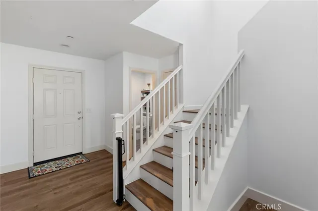 a view of staircase with wooden floor and white walls