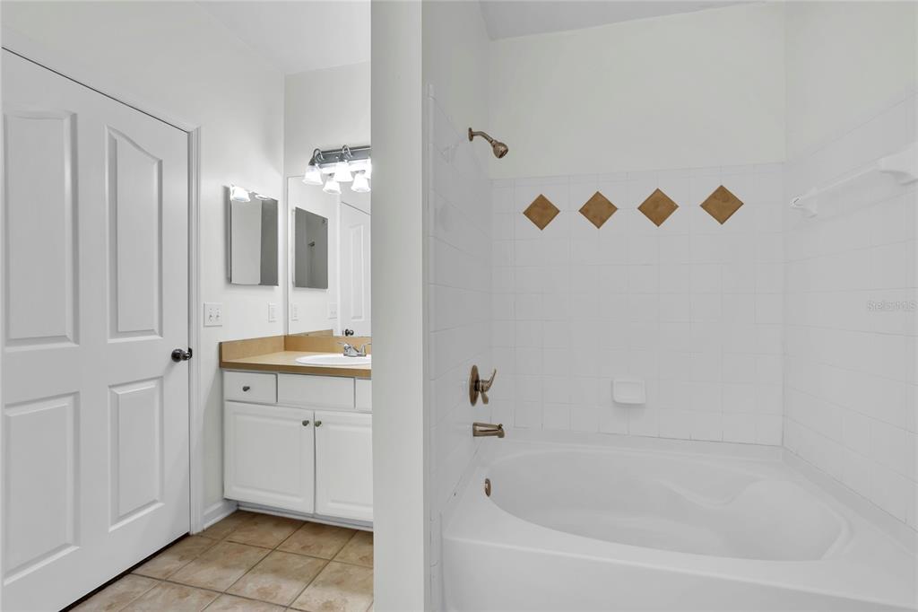 12831 Madison Pointe Circle, Unit 107 Orlando, FL 32821 - Photo 8 of 11 a bathroom with a bathtub and a shower