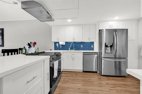 a kitchen with a refrigerator and a stove top oven