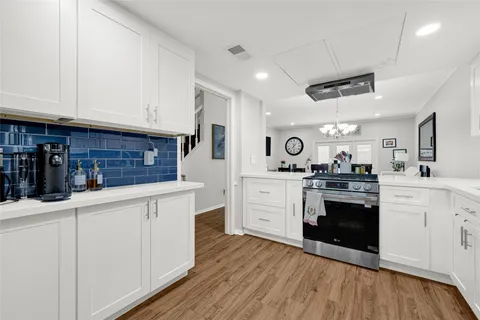 a kitchen with granite countertop a sink cabinets stainless steel appliances and wooden floor