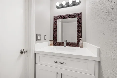 a bathroom with a sink vanity and a mirror