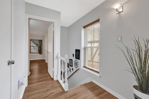 a view of a hallway with wooden floor and a living room