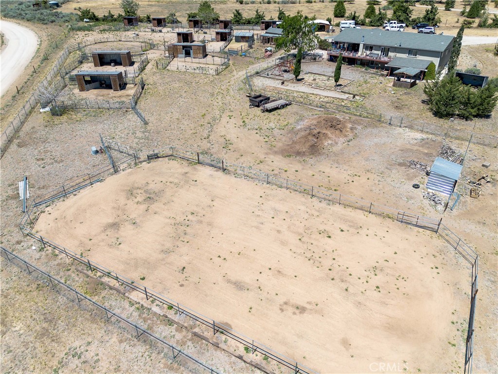 10960 Steinhoff Road Frazier Park, CA 93225 - Photo 11 of 46 An expansive, elevated aerial perspective that showcases the extensive footprint of the property, highlighting the massive fenced riding arena, covered horse stalls, and the main residence with its expansive deck.