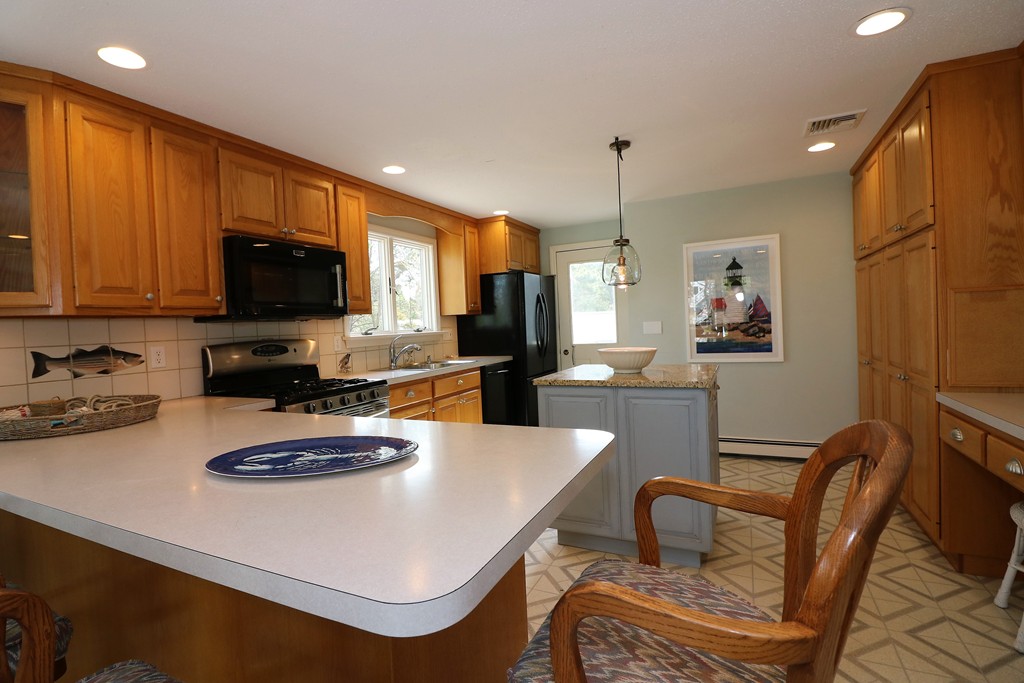36 Ide-Ho Lane Eastham, MA 02642 - Photo 5 of 30 a kitchen with a dining table and chairs