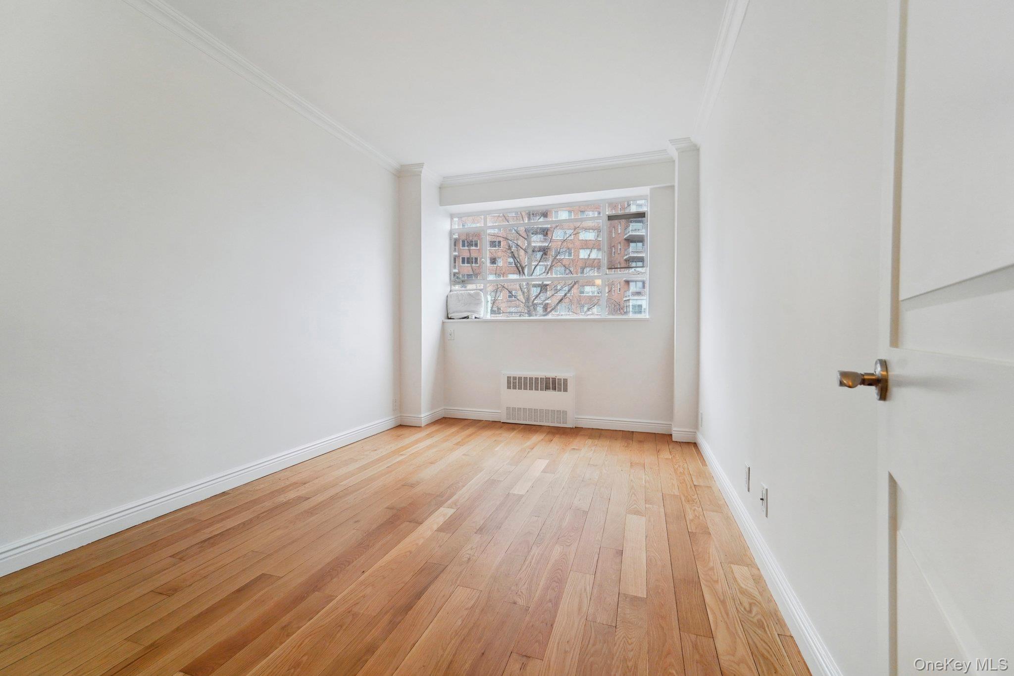 2727 Palisade Avenue, Unit 4H Bronx, NY 10463 - Photo 12 of 26 an empty room with wooden floor and windows