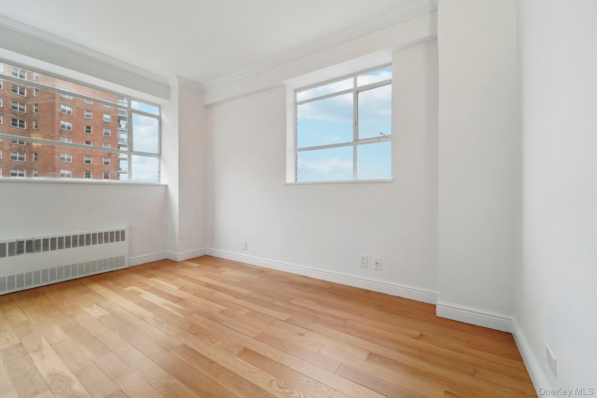 2727 Palisade Avenue, Unit 4H Bronx, NY 10463 - Photo 15 of 26 an empty room with wooden floor and windows