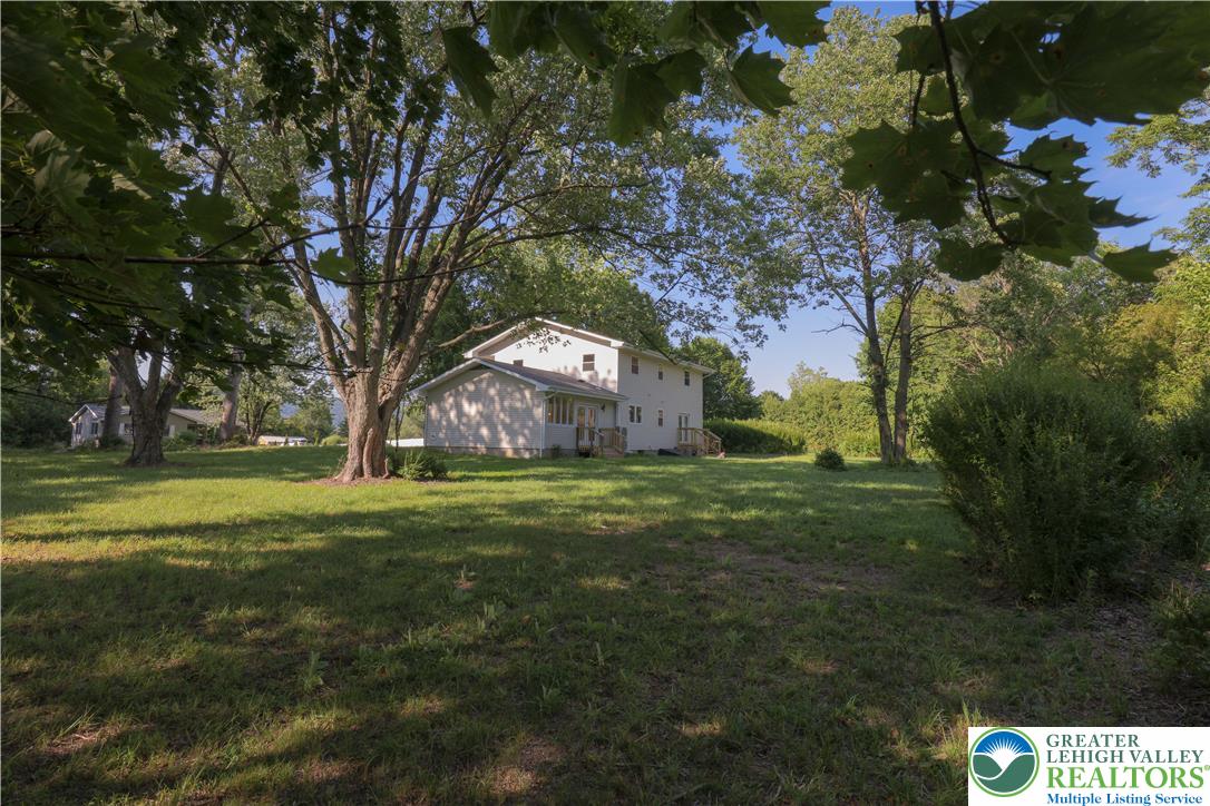 919 Point Phillips Road Bath, PA 18014 - Photo 49 of 59 A spacious yard with mature shade trees frames this charming, light-colored home.