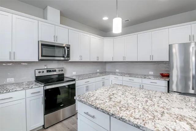 a kitchen with stainless steel appliances granite countertop a stove a sink and a refrigerator