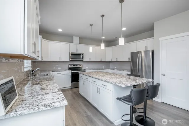 a kitchen with a stove a refrigerator and a sink