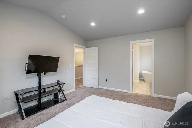 a bedroom with a bed and a flat screen tv