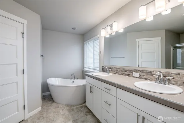 a bathroom with a white tub a sink and a mirror