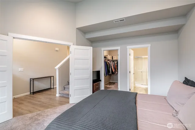 a bedroom with a bed and a view of kitchen
