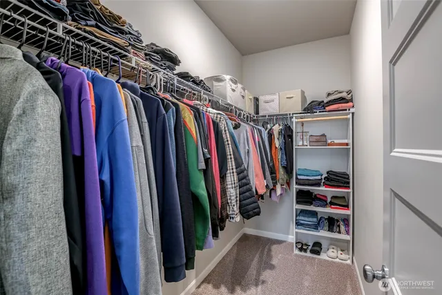 a view of walk in closet with clothes and shoes