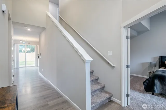 a view of a hallway with wooden floor and staircase