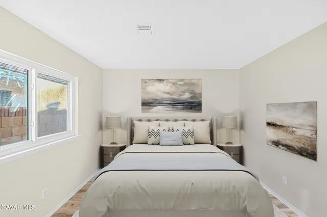 a bedroom with a bed and a painting on the wall