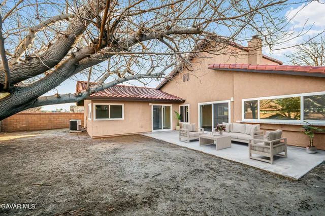 a white house that has a tree in front of it