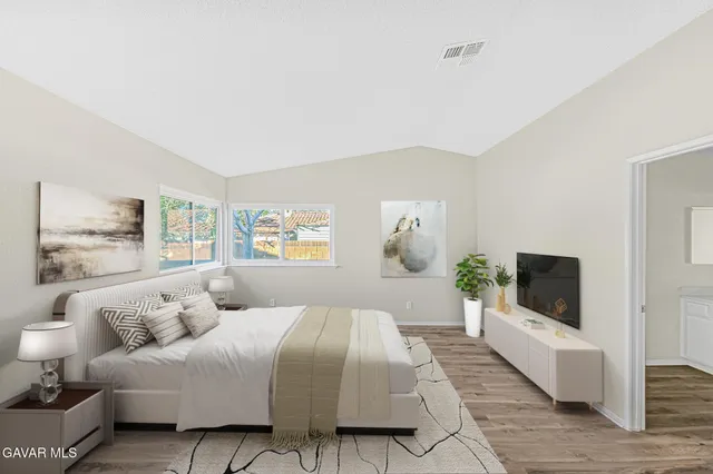 a bedroom with a large bed and a flat screen tv