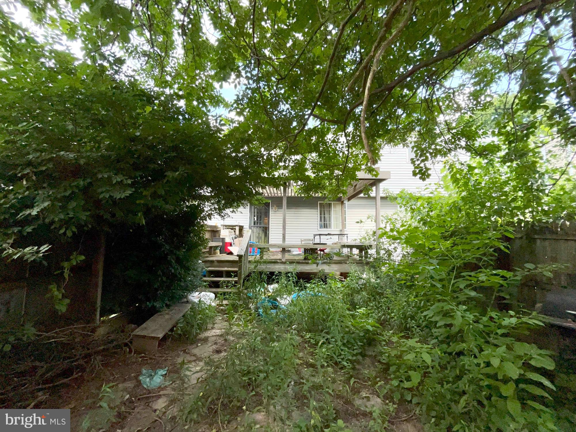 12366 Bonfire Drive Reisterstown, MD 21136 - Photo 20 of 20 a backyard of a house with table and chairs and a large tree