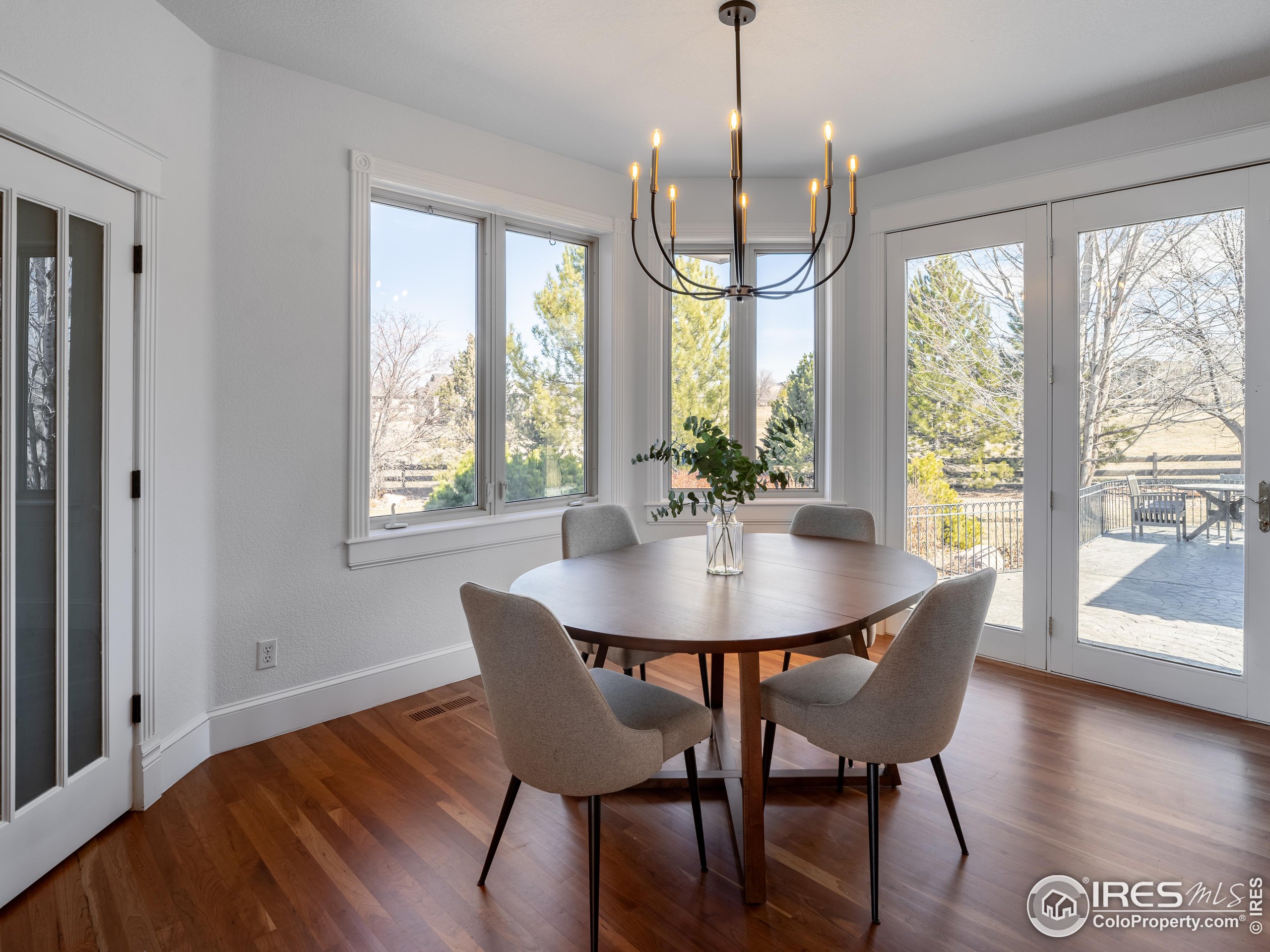 385 Baxter Farm Lane Erie, CO 80516 - Photo 13 of 40 a view of a dining room with furniture window and wooden floor
