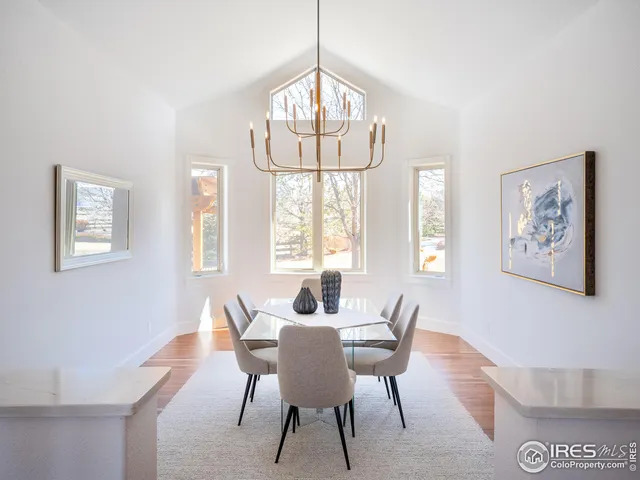 a dining room with wooden floor and a chandelier