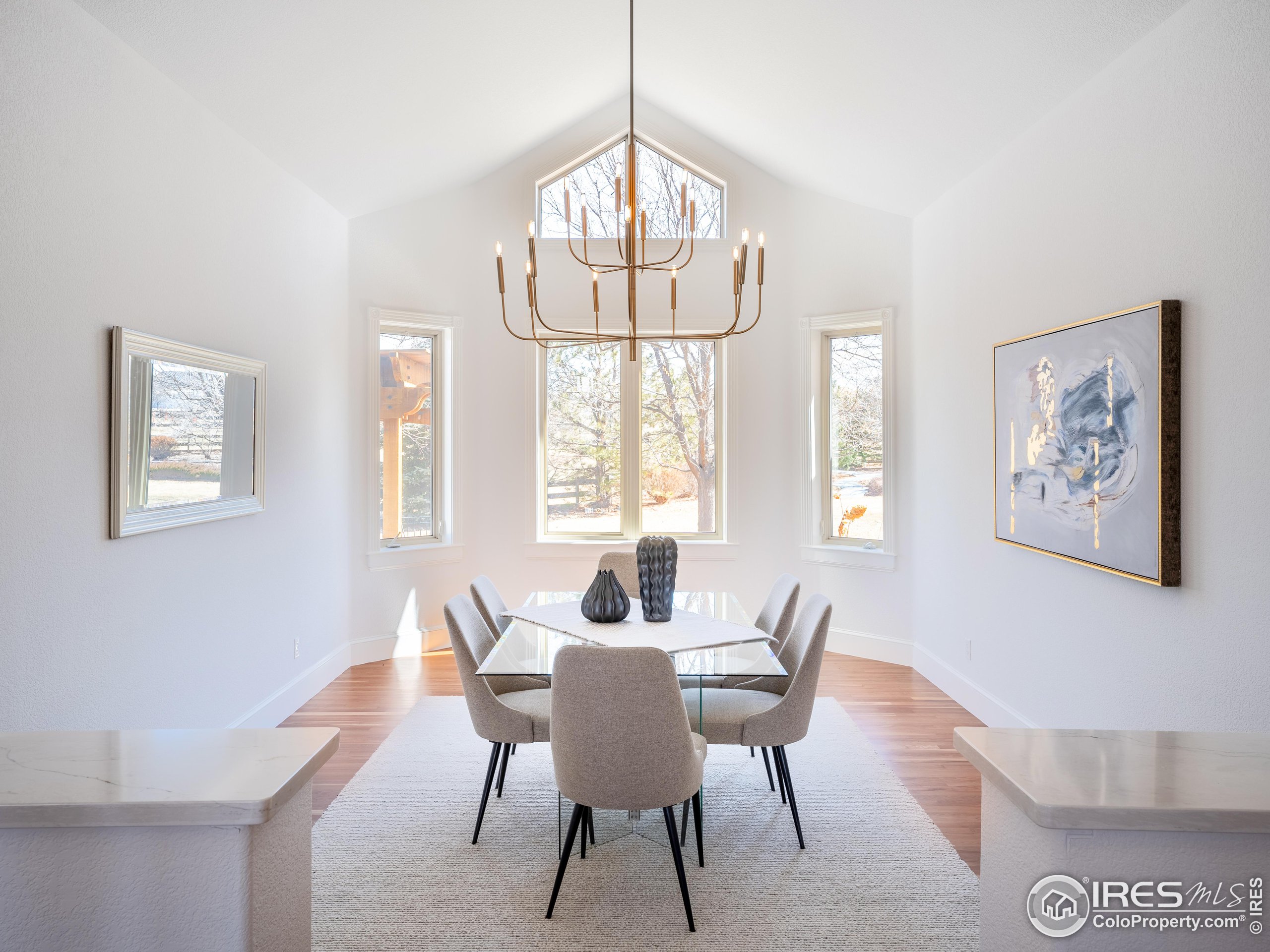 385 Baxter Farm Lane Erie, CO 80516 - Photo 17 of 40 a dining room with wooden floor and a chandelier
