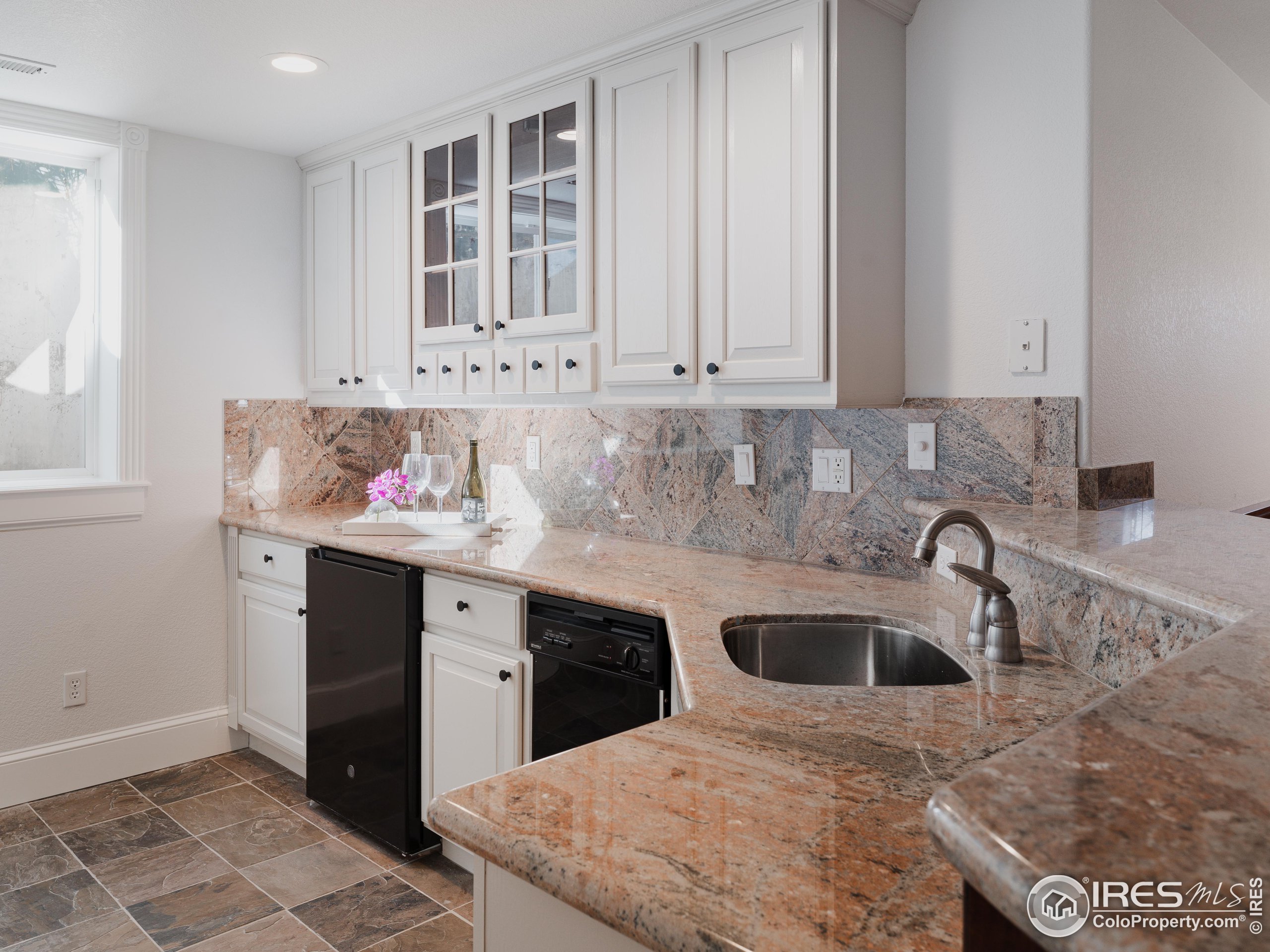 385 Baxter Farm Lane Erie, CO 80516 - Photo 32 of 40 a kitchen with granite countertop a sink a stove and cabinets